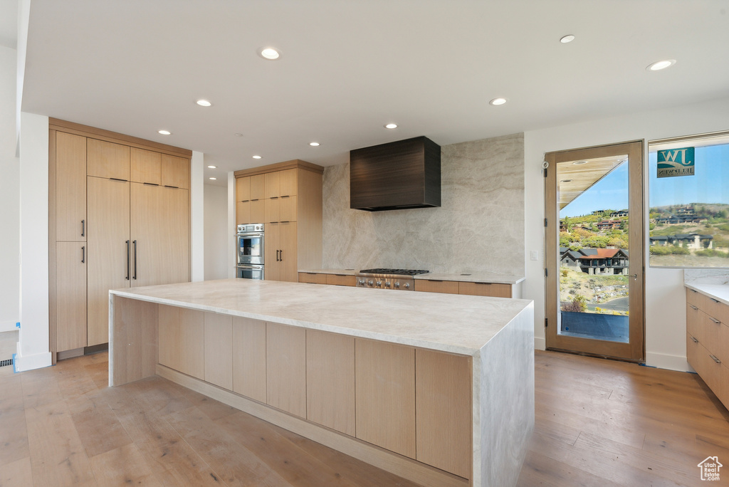 Kitchen featuring a center island, light wood-type flooring, and light brown cabinets