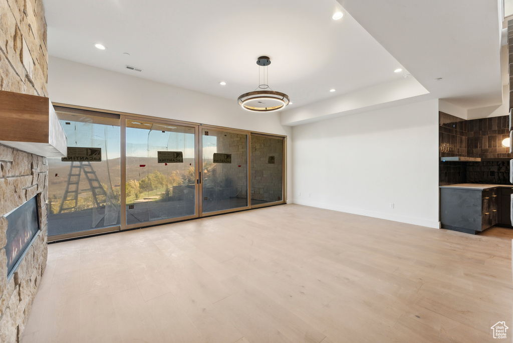 Unfurnished living room featuring a stone fireplace