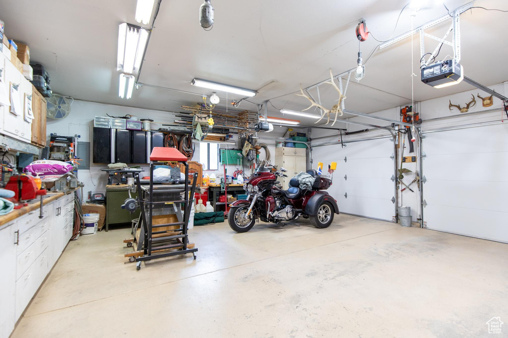 Garage featuring a workshop area and a garage door opener