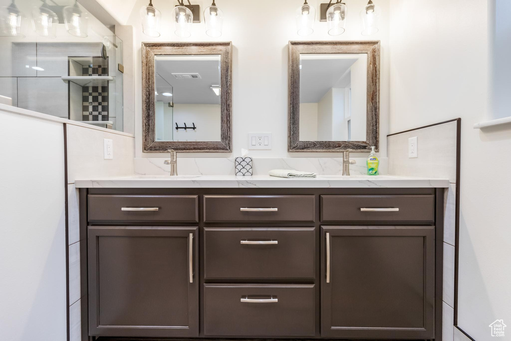 Bathroom with tasteful backsplash and dual bowl vanity