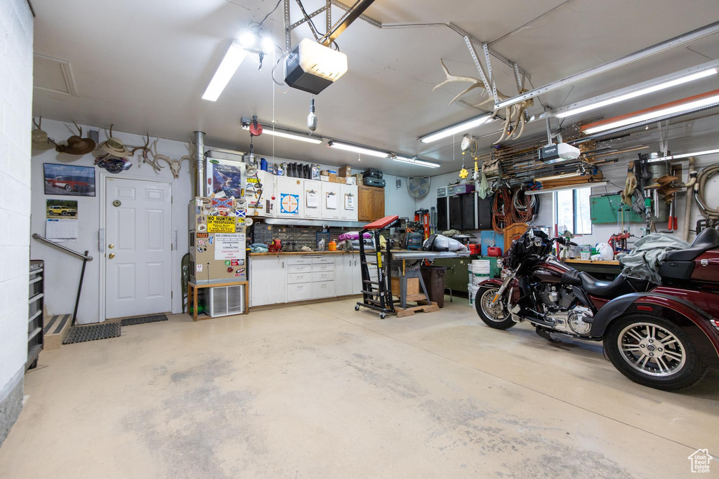 Garage featuring a workshop area and a garage door opener