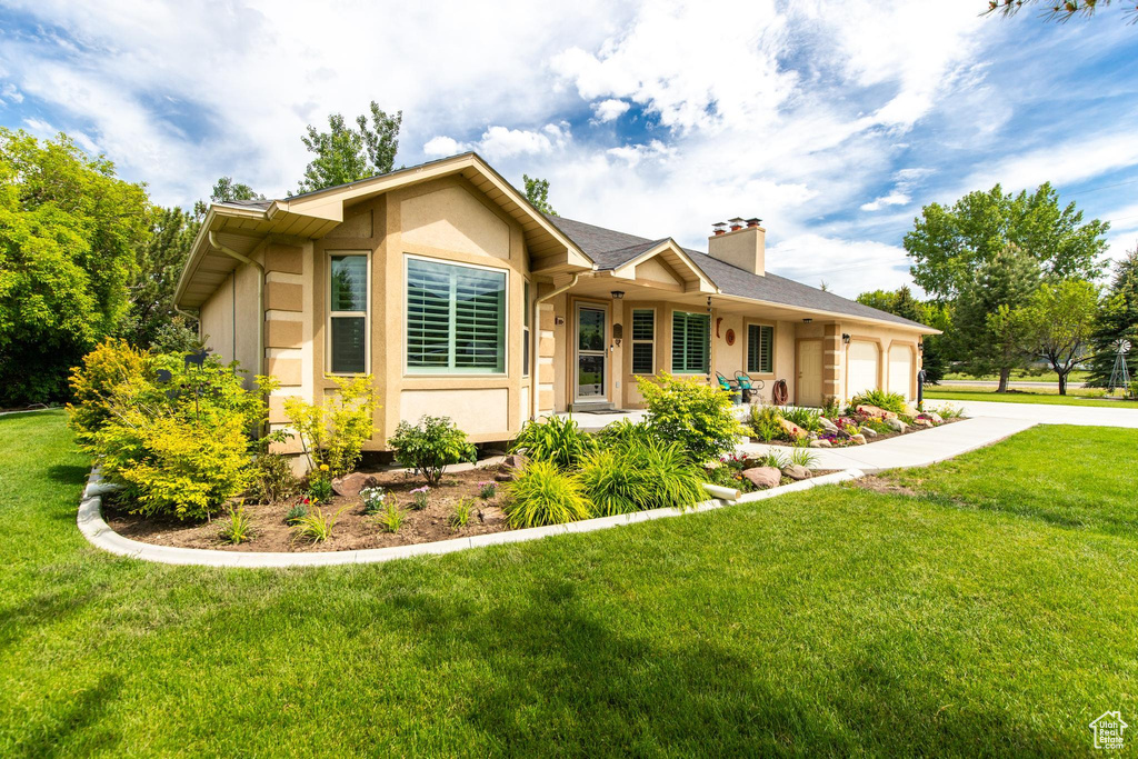 Ranch-style home featuring a garage and a front yard