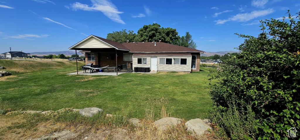 Rear view of property featuring a patio and a lawn