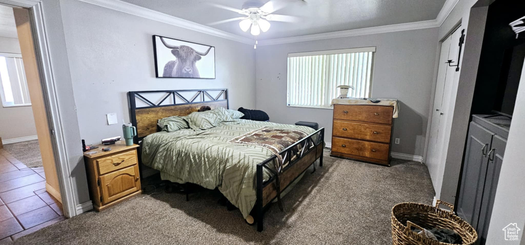 Bedroom with ceiling fan, tile patterned flooring, and crown molding