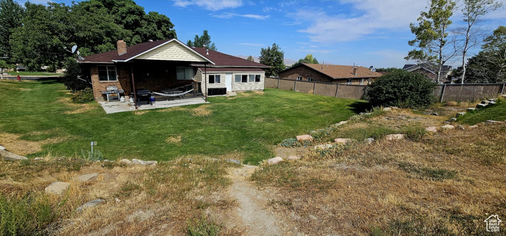 Rear view of house featuring a patio area and a lawn