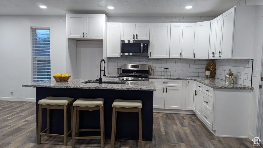 Kitchen with sink, appliances with stainless steel finishes, and white cabinetry