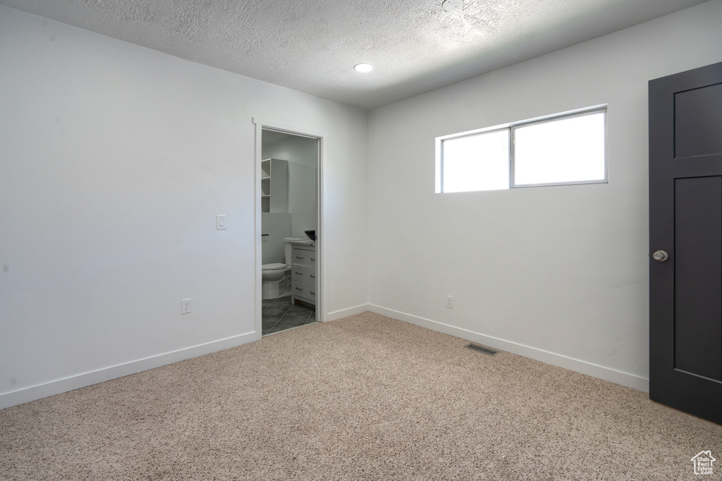 Spare room featuring carpet and a textured ceiling