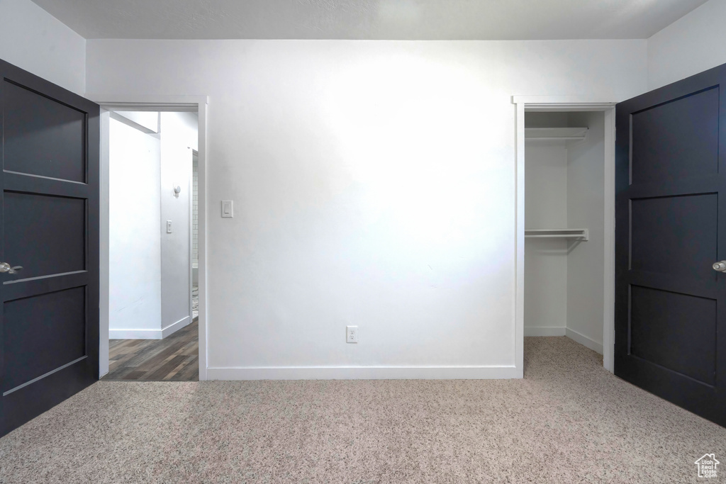 Unfurnished bedroom featuring dark wood-type flooring and a closet