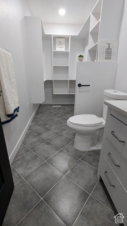 Bathroom featuring vanity, toilet, and tile patterned flooring