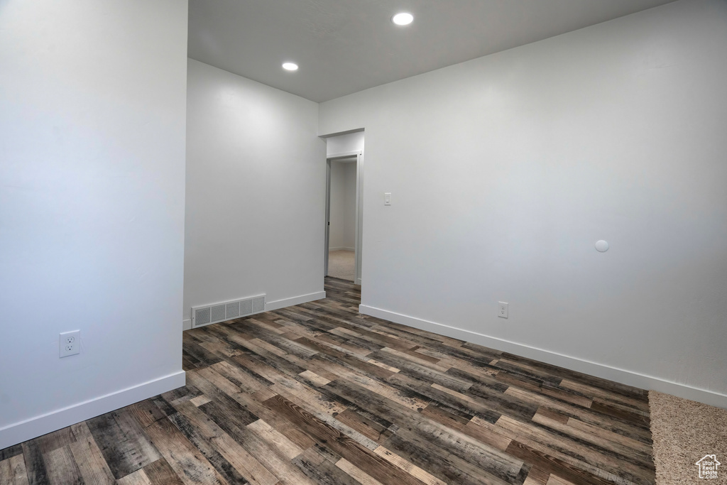 Empty room with dark wood-type flooring