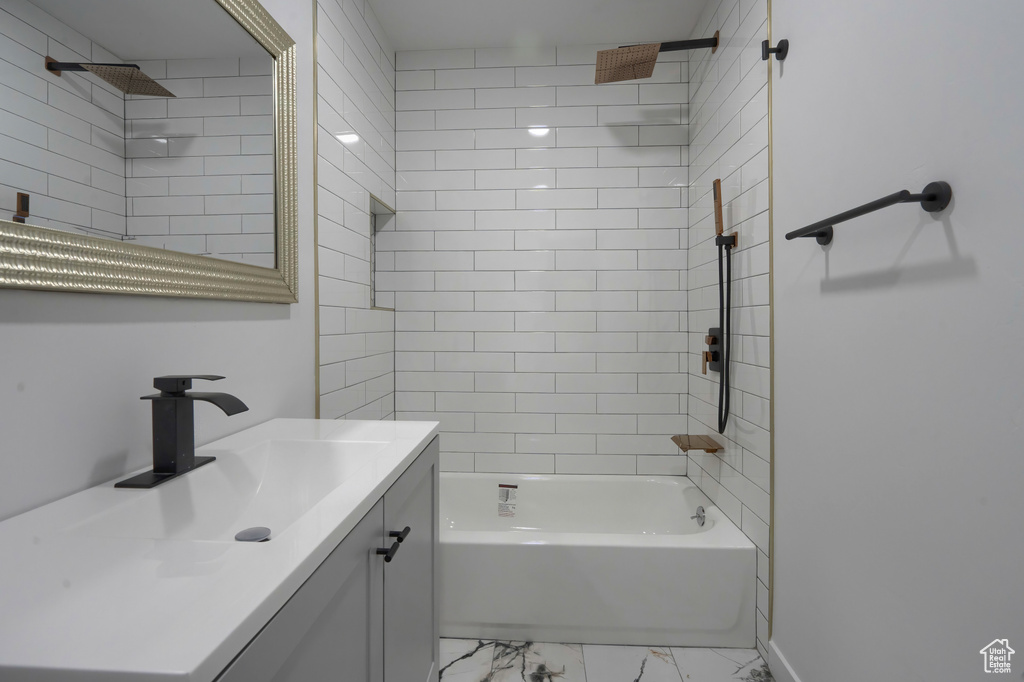 Bathroom featuring vanity with extensive cabinet space, tiled shower / bath combo, and tile floors