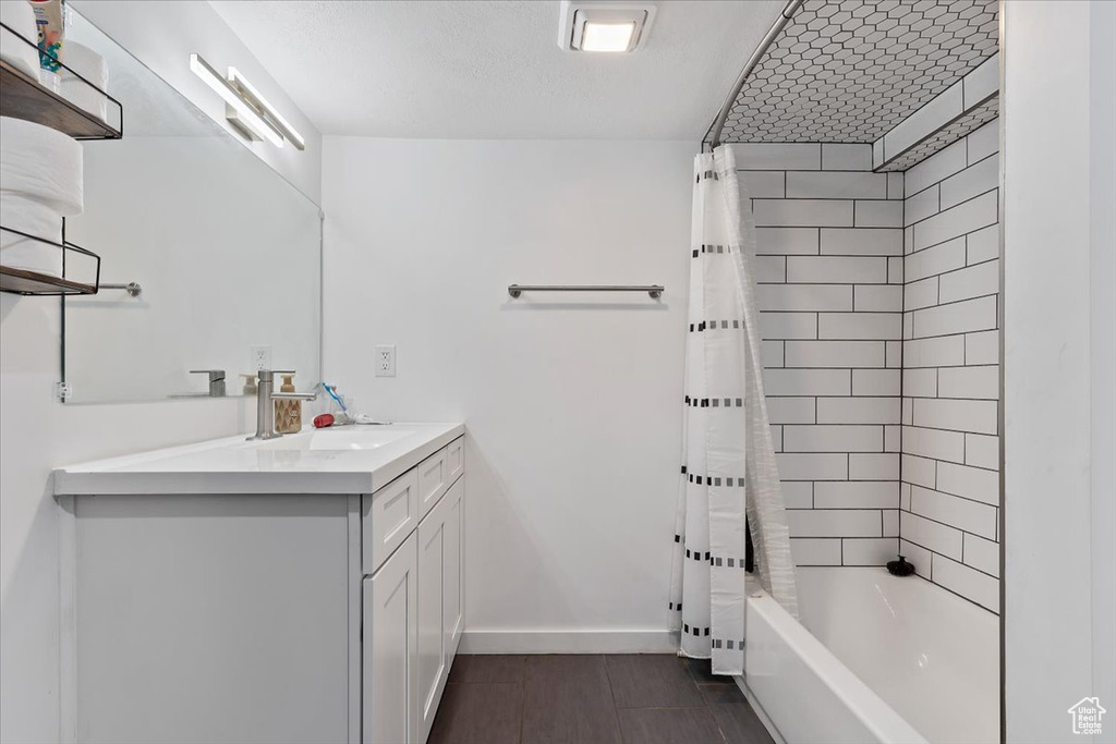 Bathroom featuring tile floors, shower / bath combination with curtain, and vanity