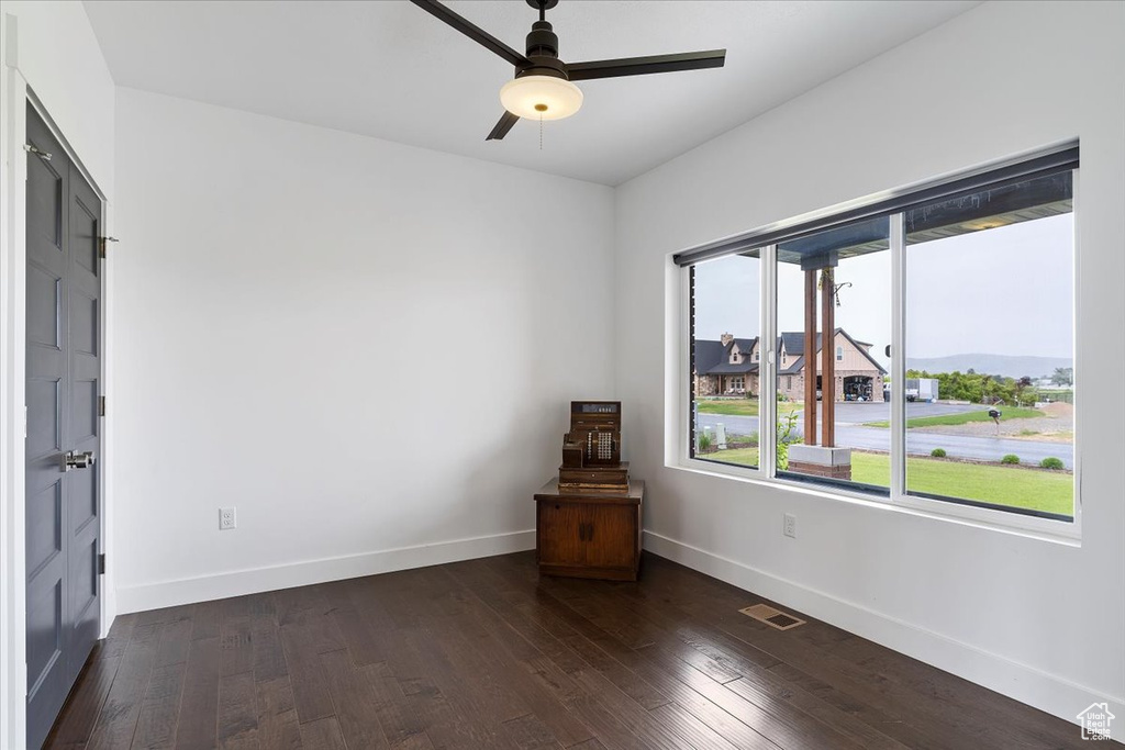 Unfurnished room with dark hardwood / wood-style flooring and ceiling fan