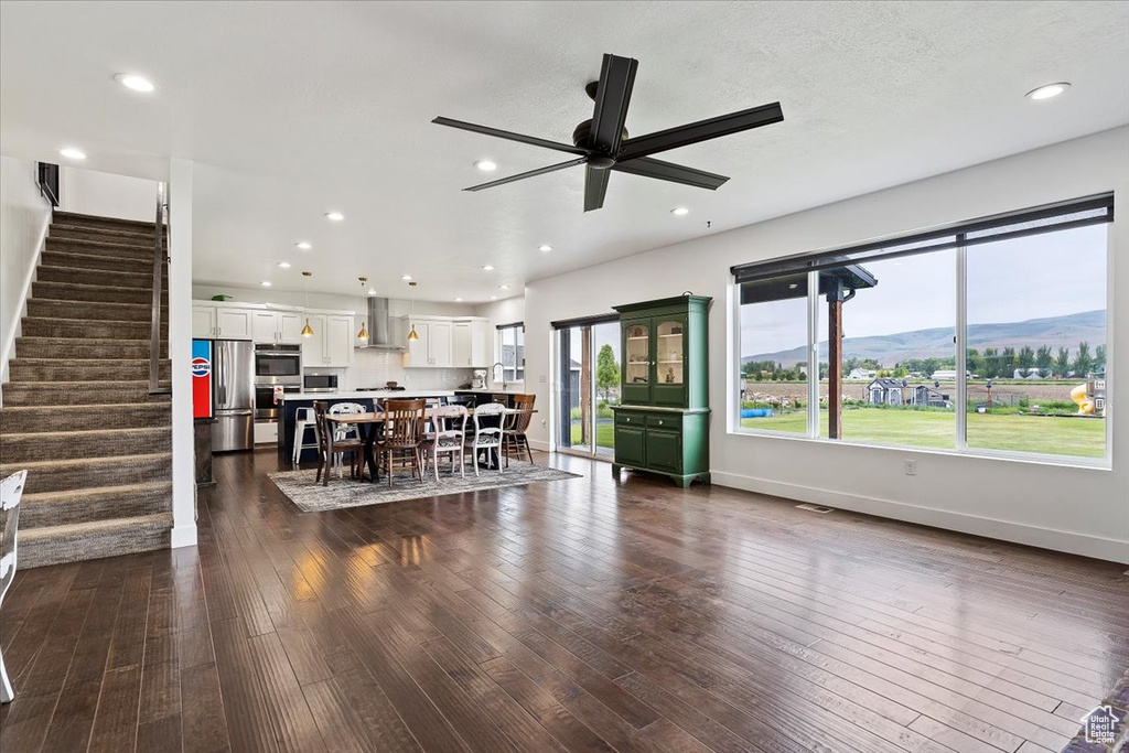 Interior space featuring a mountain view, stainless steel appliances, dark hardwood / wood-style flooring, white cabinets, and wall chimney exhaust hood