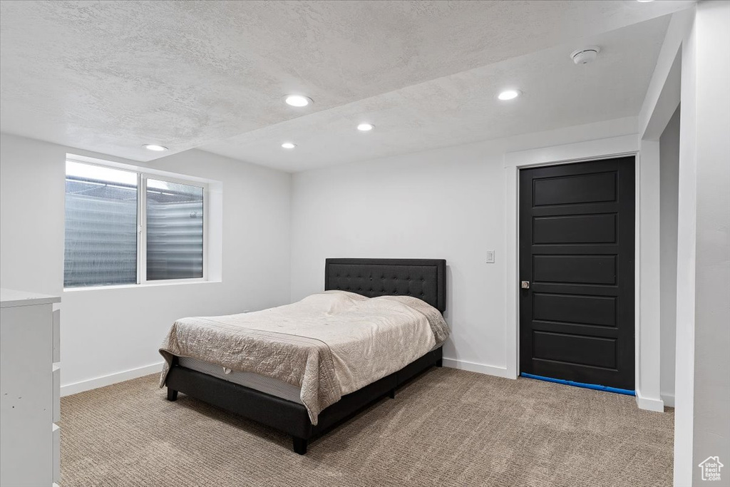 Bedroom with a textured ceiling and carpet flooring