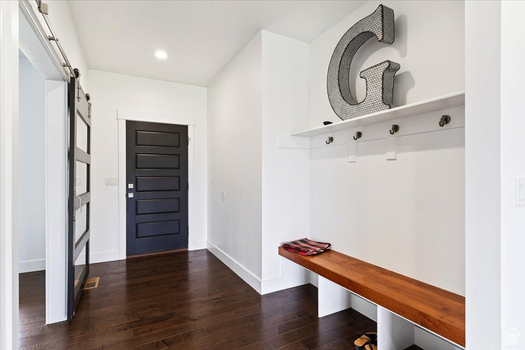 Mudroom with dark hardwood / wood-style floors and a barn door