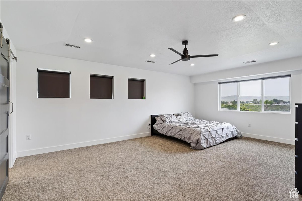 Unfurnished bedroom featuring carpet, ceiling fan, and a textured ceiling