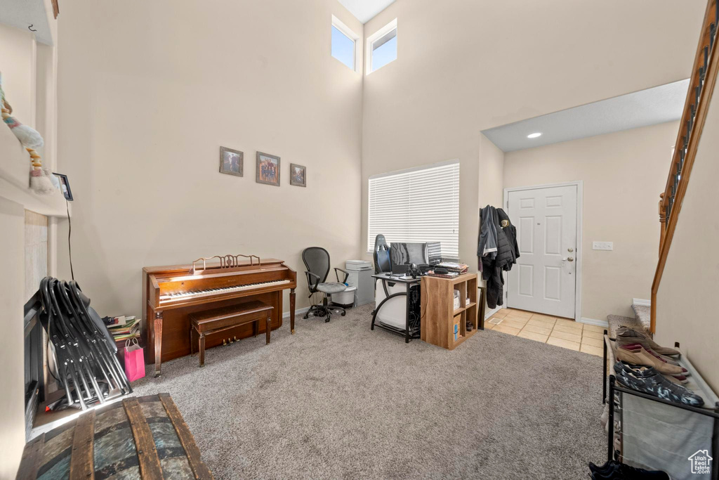 Office with a towering ceiling and carpet flooring