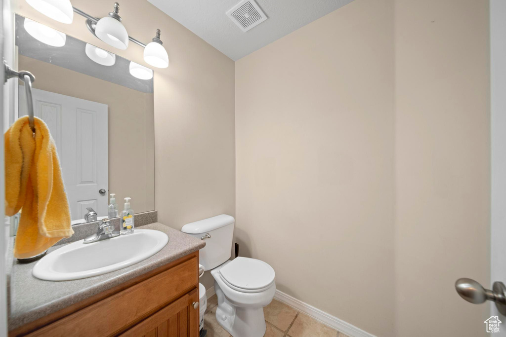 Bathroom with tile flooring, vanity, and toilet