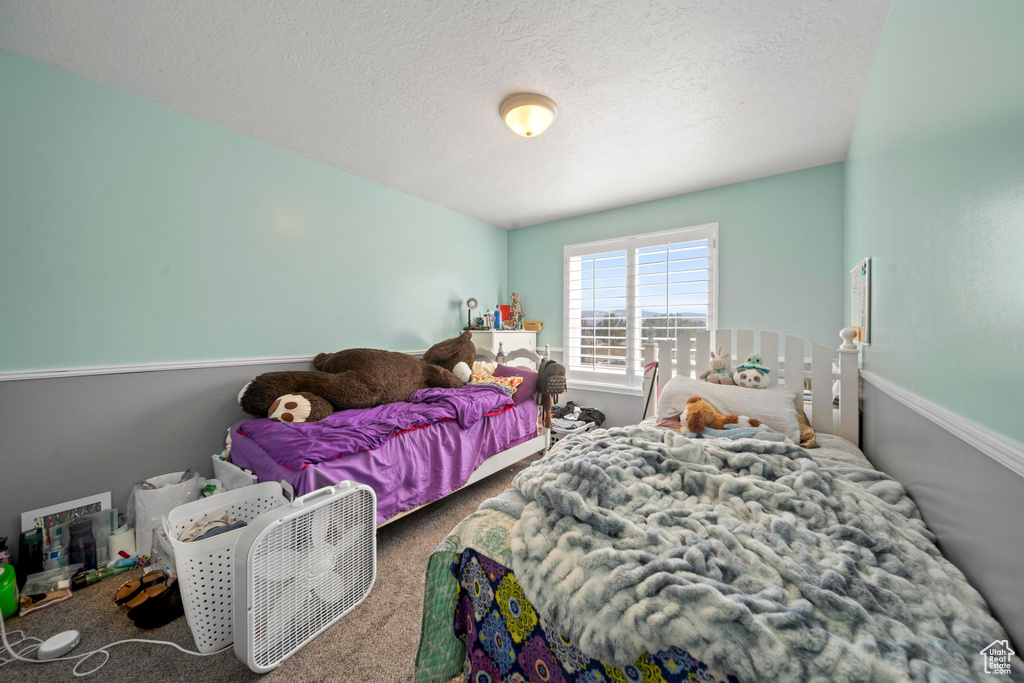 Carpeted bedroom with a textured ceiling