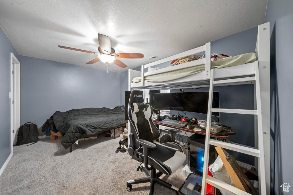 Bedroom featuring carpet, ceiling fan, and a textured ceiling