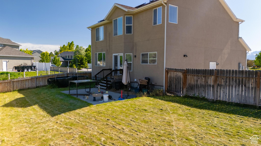 Back of property with a yard and a patio area