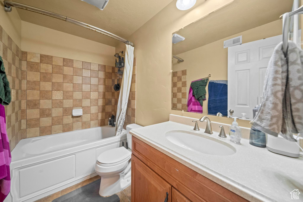 Full bathroom with toilet, oversized vanity, and shower / bath combo