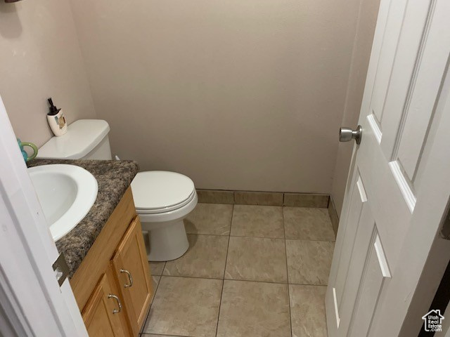 Bathroom with tile flooring, vanity, and toilet