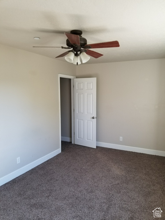 Interior space featuring dark carpet and ceiling fan