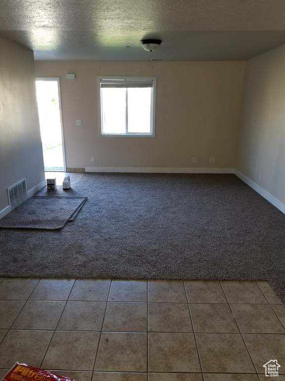 Tiled spare room featuring a textured ceiling