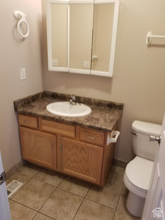 Bathroom featuring tile flooring, vanity, and toilet