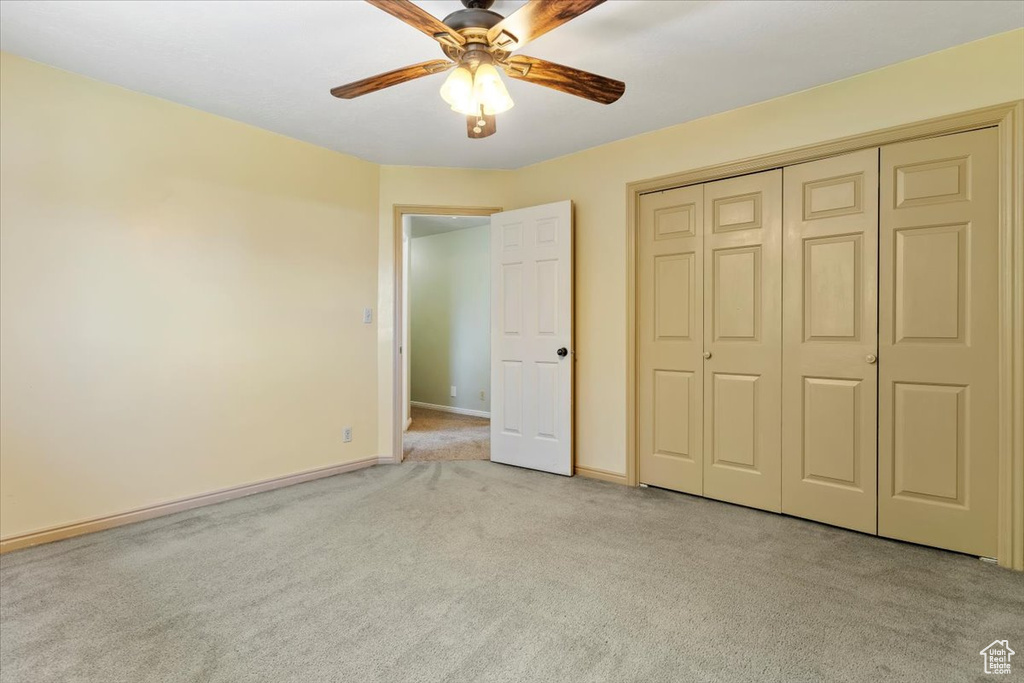 Unfurnished bedroom featuring a closet, carpet floors, and ceiling fan