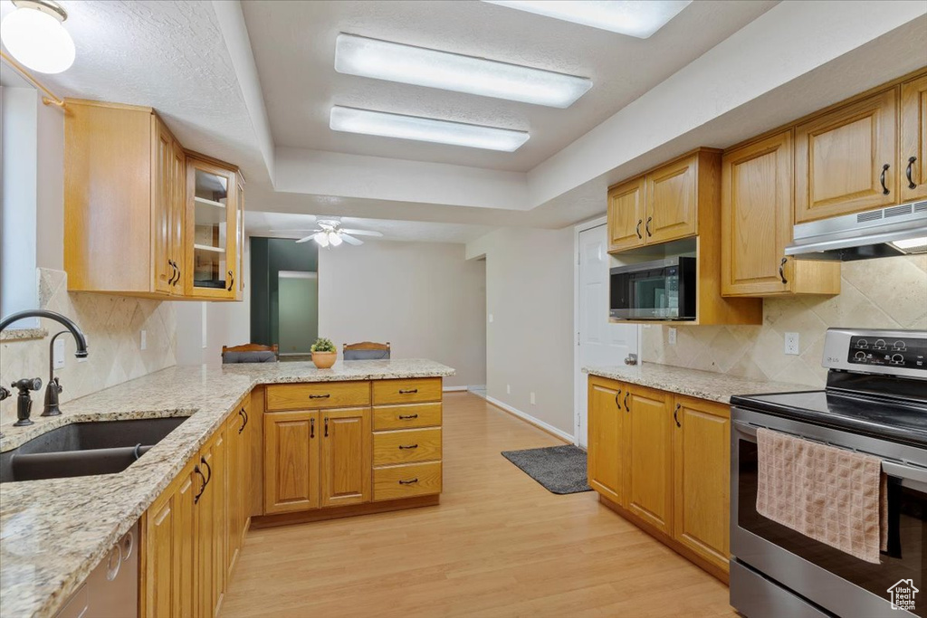 Kitchen featuring ceiling fan, light hardwood / wood-style floors, tasteful backsplash, built in microwave, and stainless steel electric stove