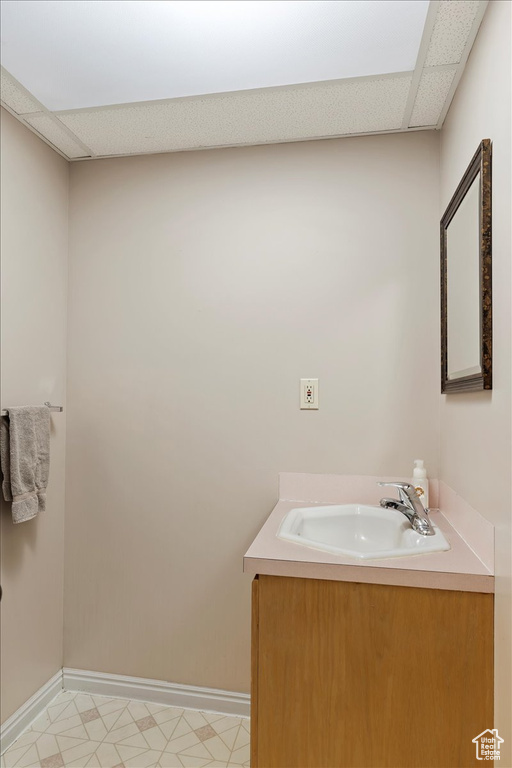 Bathroom featuring tile flooring, a paneled ceiling, and vanity