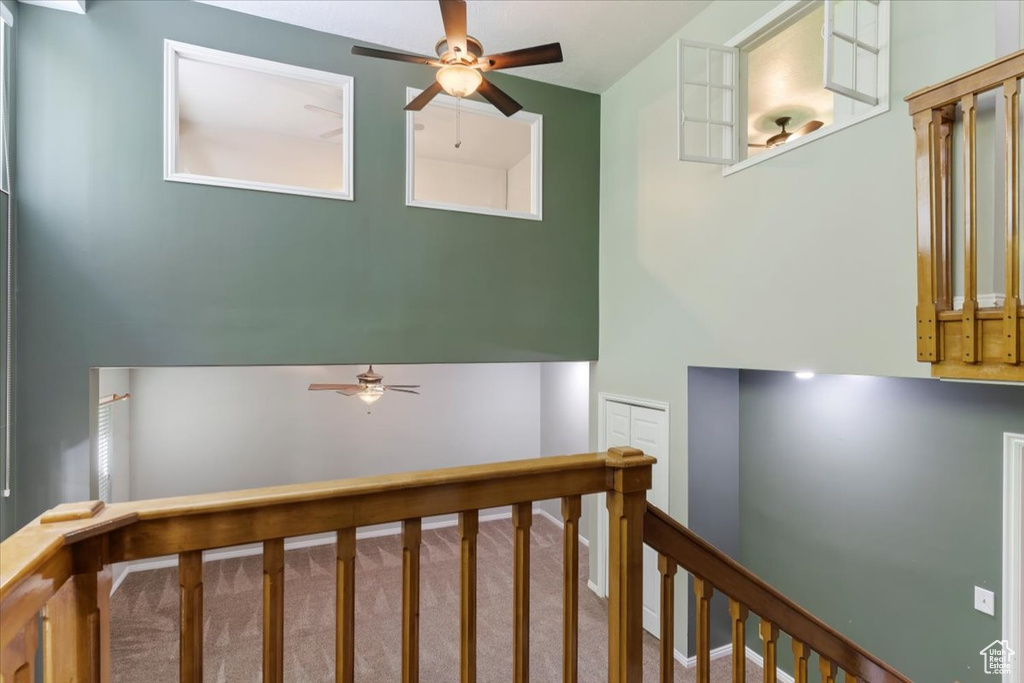 Stairway with ceiling fan and carpet floors