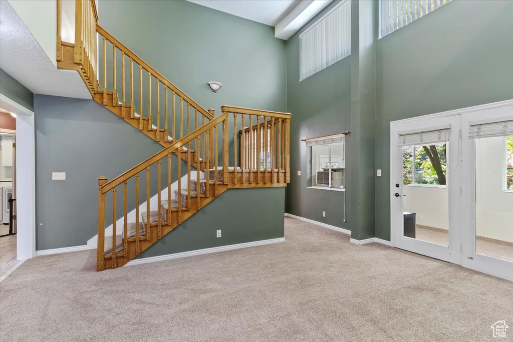 Interior space with carpet flooring and a towering ceiling