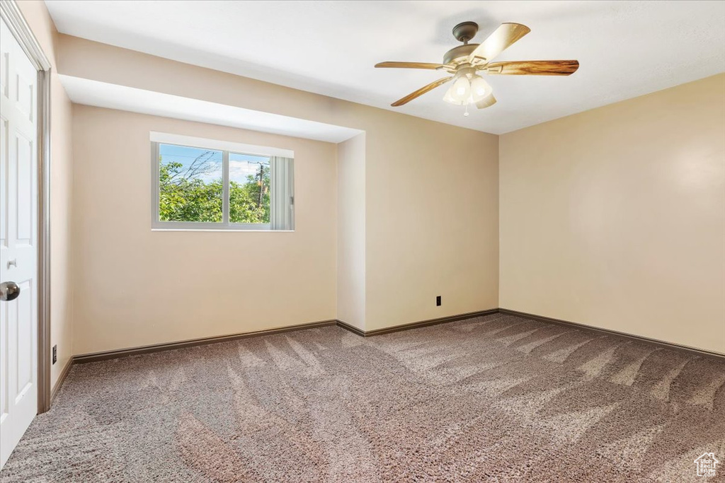 Empty room featuring carpet and ceiling fan