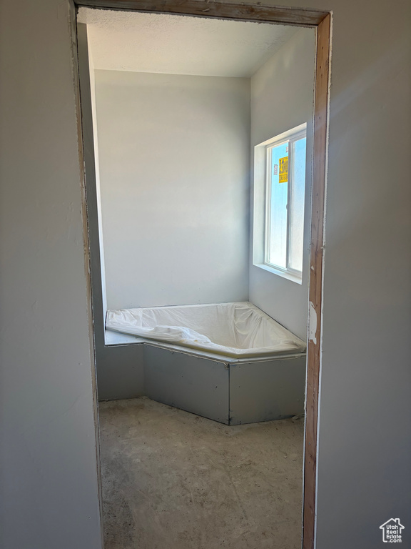 Bathroom featuring concrete floors and a tub