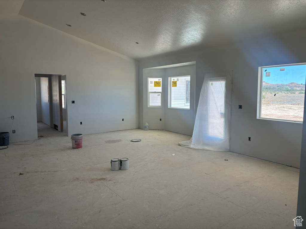 Interior space featuring a textured ceiling and lofted ceiling