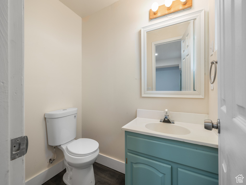 Bathroom featuring vanity, hardwood / wood-style flooring, and toilet