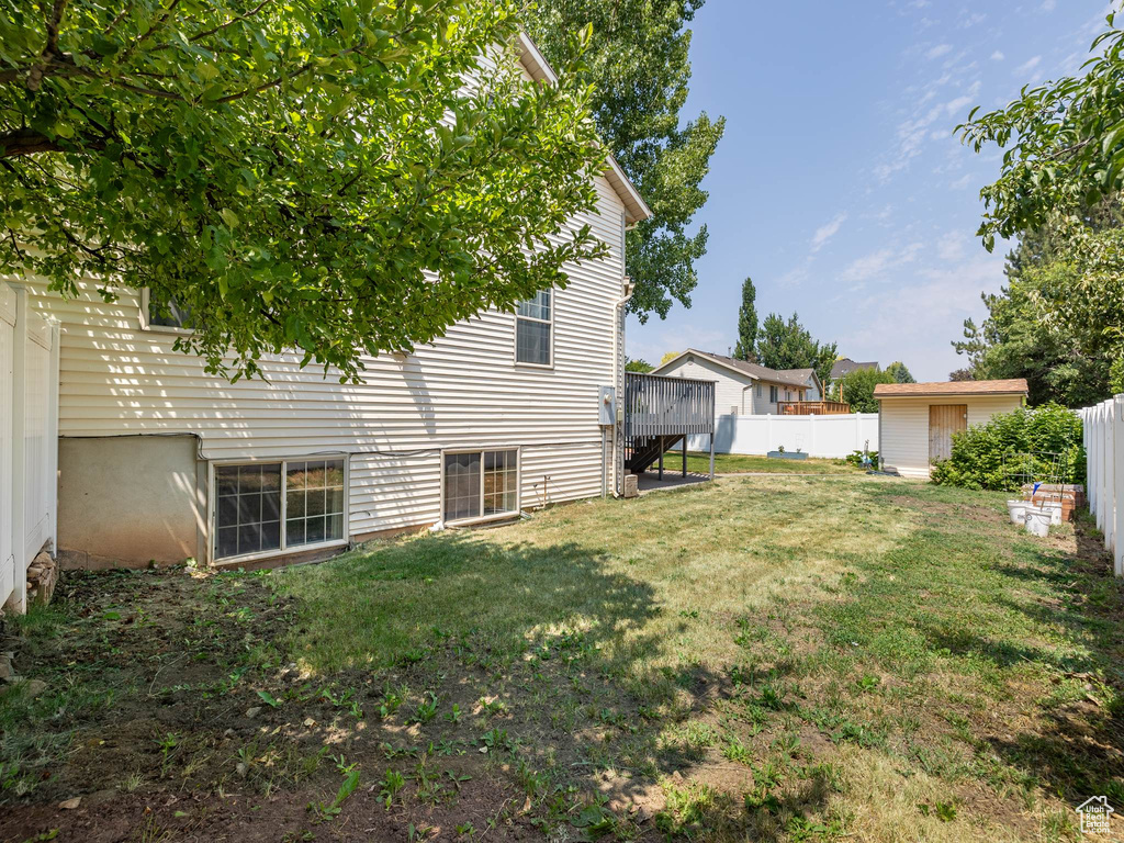 View of yard with a storage shed and a wooden deck