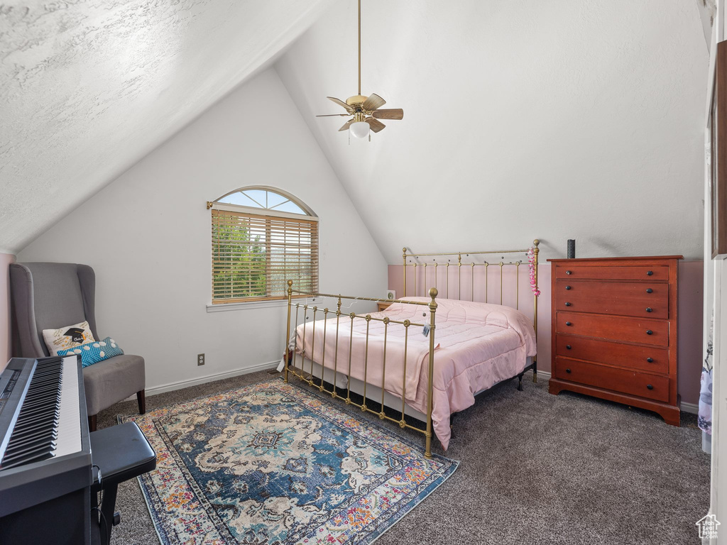 Bedroom featuring ceiling fan, dark colored carpet, a textured ceiling, and lofted ceiling