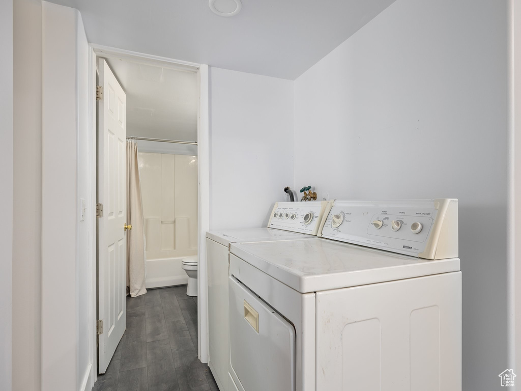 Laundry room with independent washer and dryer and dark hardwood / wood-style flooring