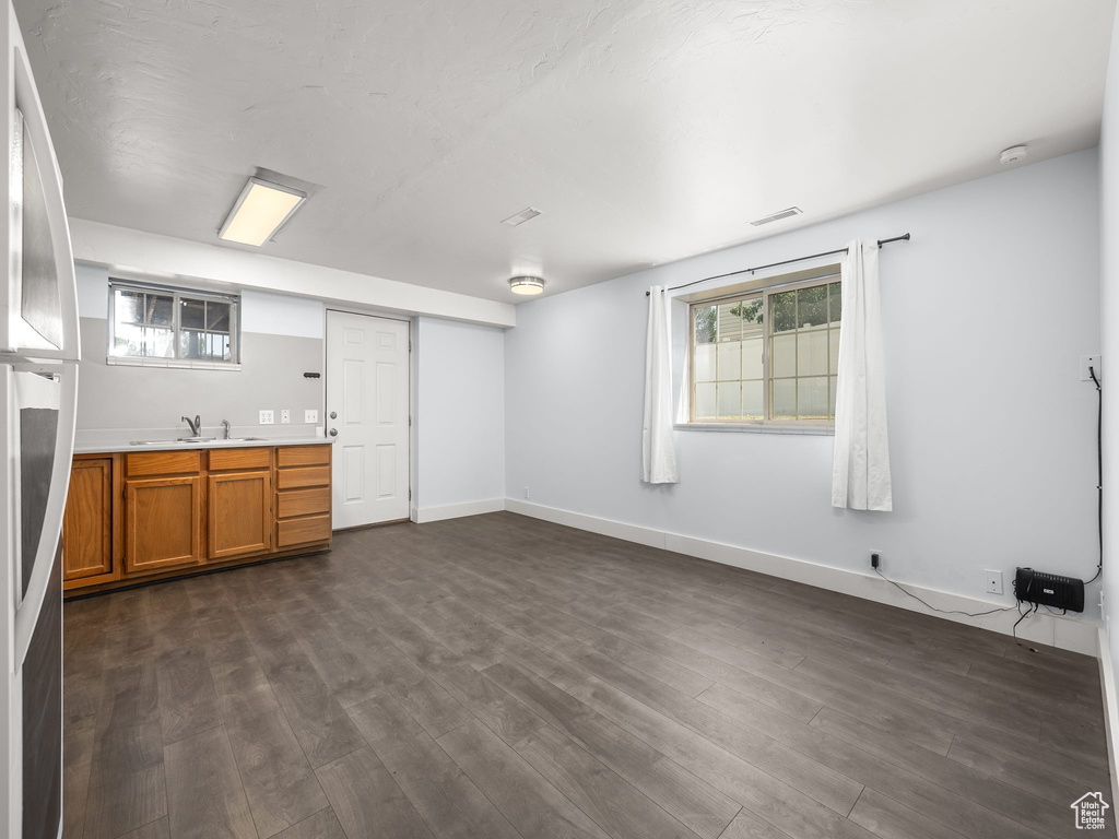 Unfurnished living room with sink and dark wood-type flooring