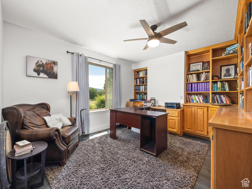 Office space featuring dark hardwood / wood-style flooring, ceiling fan, and a textured ceiling