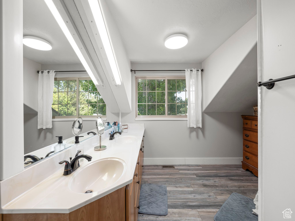 Bathroom featuring hardwood / wood-style floors, dual sinks, and large vanity