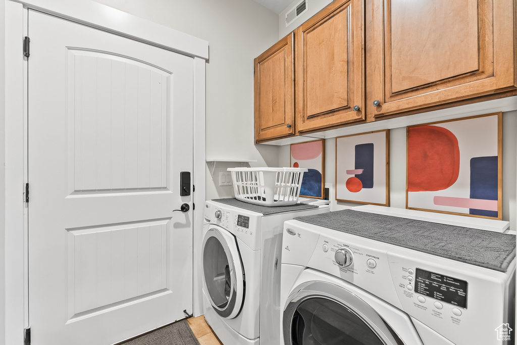 Laundry area featuring cabinets and independent washer and dryer