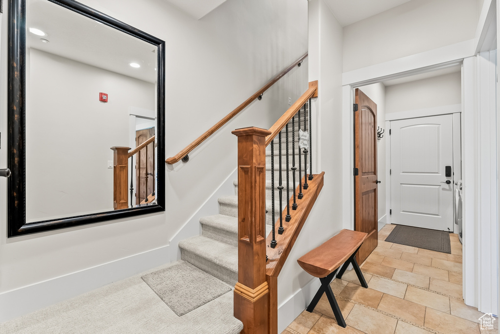 Stairway featuring light tile floors