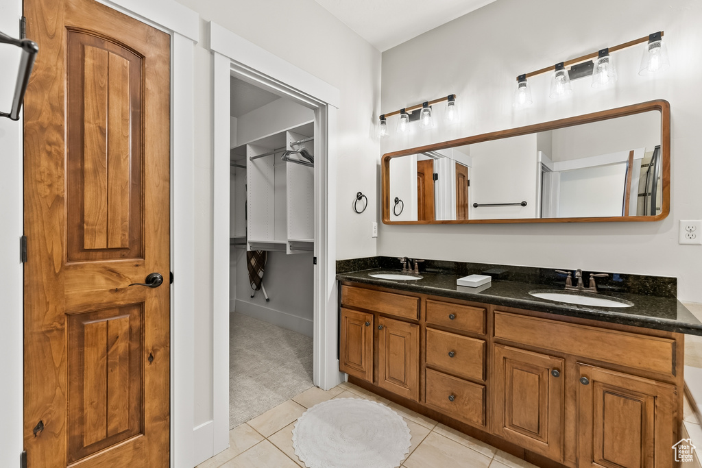 Bathroom with oversized vanity, double sink, and tile floors