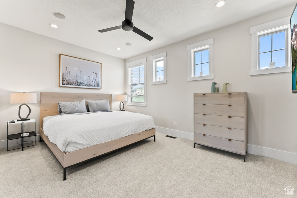 Carpeted bedroom featuring ceiling fan